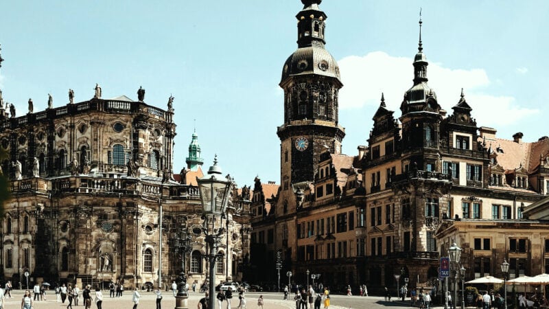 Residenzschloss Dresden und Hofkirche mit barocken Türmen, heller Sandsteinfassade und belebtem Theaterplatz.