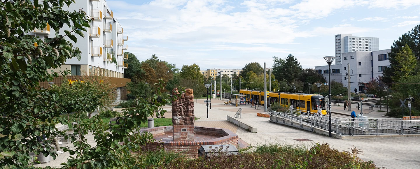 Der Amalie-Dietrich-Platz in Gorbitz mit dem denkmalgeschützten Märchenbrunnen, umgeben von urbaner Architektur und Grün.