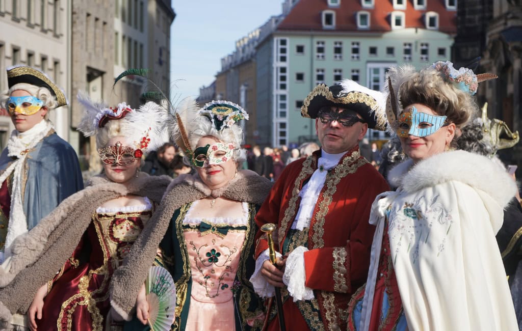 "Lust, Leidenschaft, Lebensfreude" ist das Motto des fünften Elbvenezianischen Carnevals. Auf dem Foto zu sehen sind Männer und Frauen, die in venezianischen Masken und Roben gekleidet vor der Frauenkirche in Dresden posieren.
