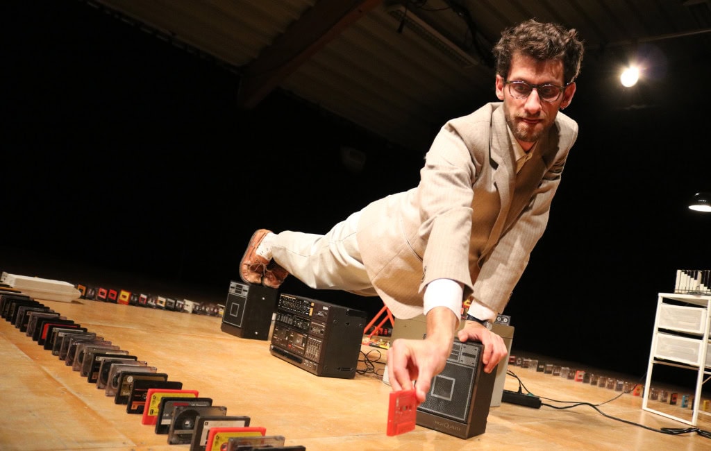 Produktion BOOMBOX beim Zirkustheater-Festival Dreden 2026: Künstler Ezra Weill stützt auf Lautsprechern und ist umgeben von Audiokassetten.