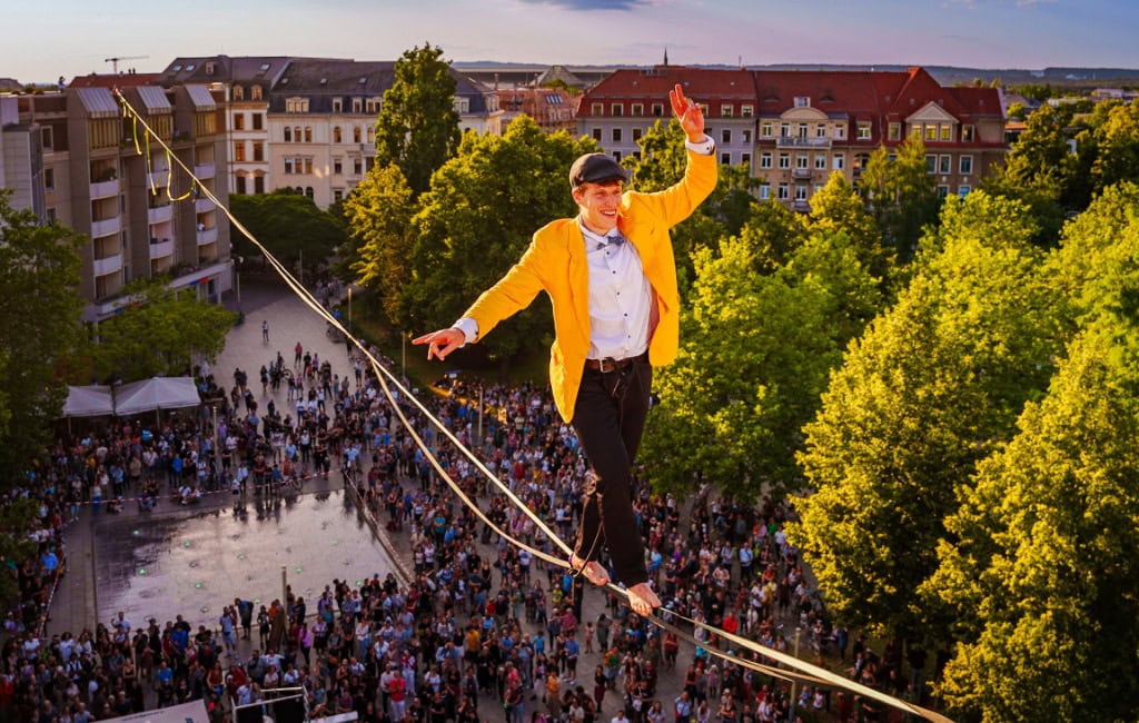 Highperformer beim Zirkustheater-Festival in Dresden 2026: Ein Mann balanciert auf einem Seil in 15 Metern Höhe.
