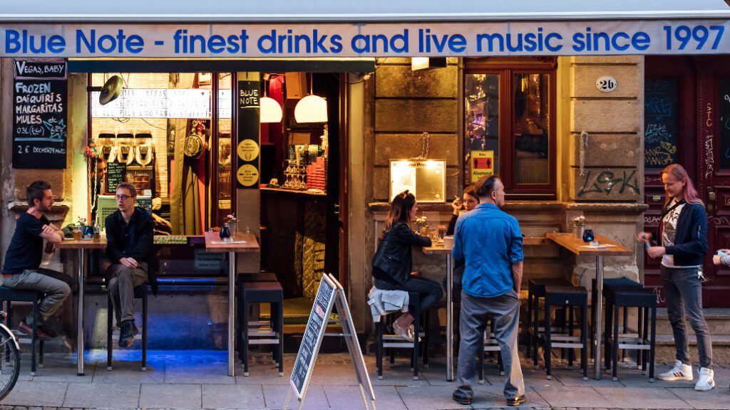 Menschen stehen auf der Straße in Dresden Neustadtvor einer Kneipe