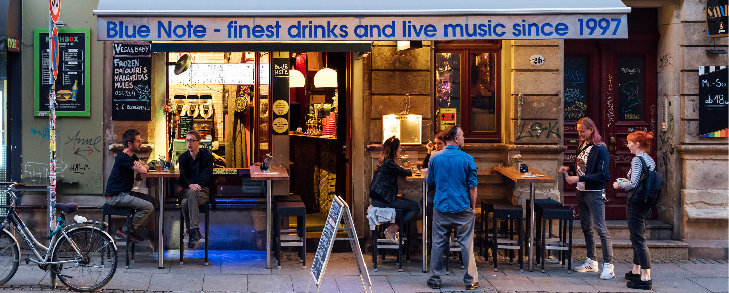 Menschen stehen auf der Straße in Dresden Neustadtvor einer Kneipe