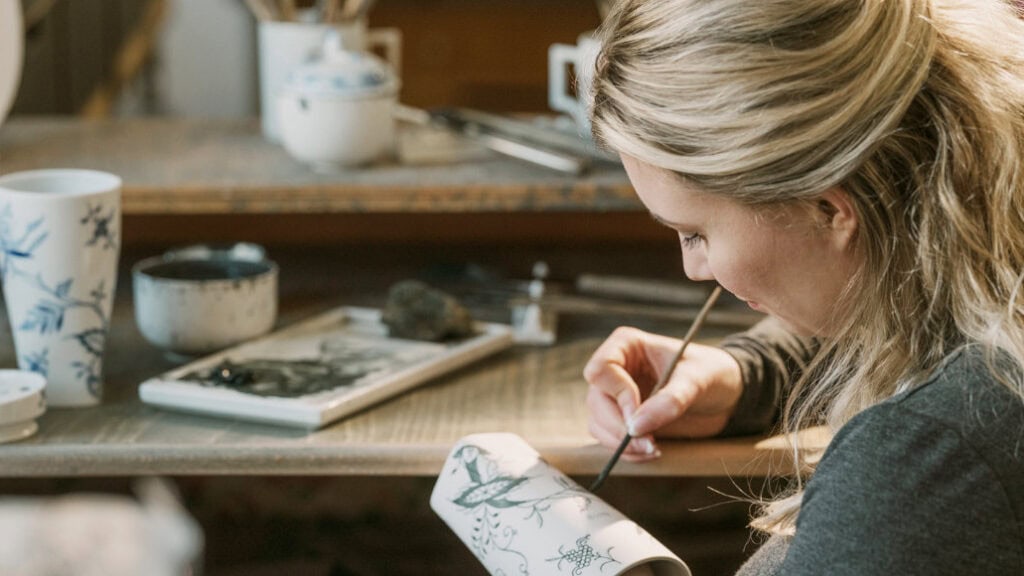 Künstlerin bemalt Porzellan in Werkstatt"