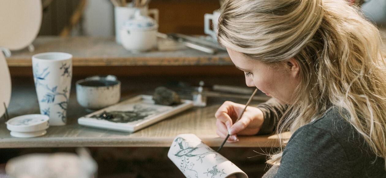 Künstlerin bemalt Porzellan in Werkstatt"