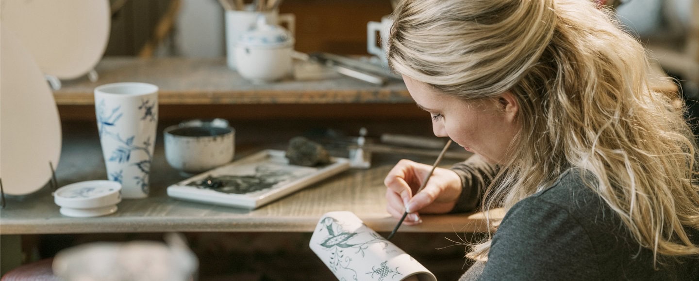 Künstlerin bemalt Porzellan in Werkstatt"