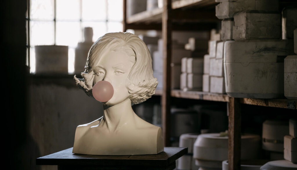 Helle Porzellanbüste von Marylin Monroe mit Kaugummiblase im Mund .