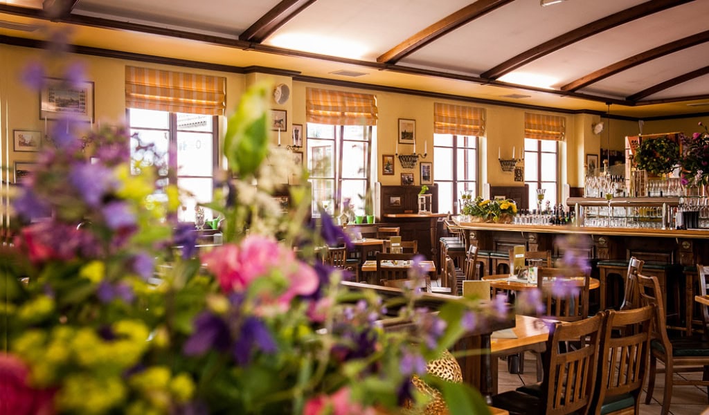 Gemütliches Brauhaus mit Holztischen, Bar und Blumenarrangements, typisches Beispiel für Brauhäuser in Dresden Elbland