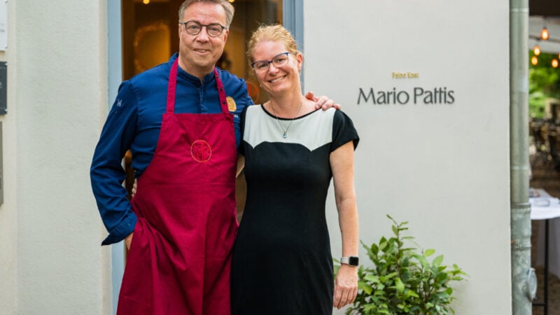 Mario Pattis udn seine Frau Simona stehen vor dem Eingang des Restaurants und lächeln