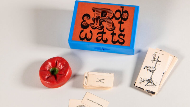 Verschiedene Gegenstände aus einer Ausstellung des Archivs der Avantgarden aus Dresden liegen auf einem weißen Hintergrund.