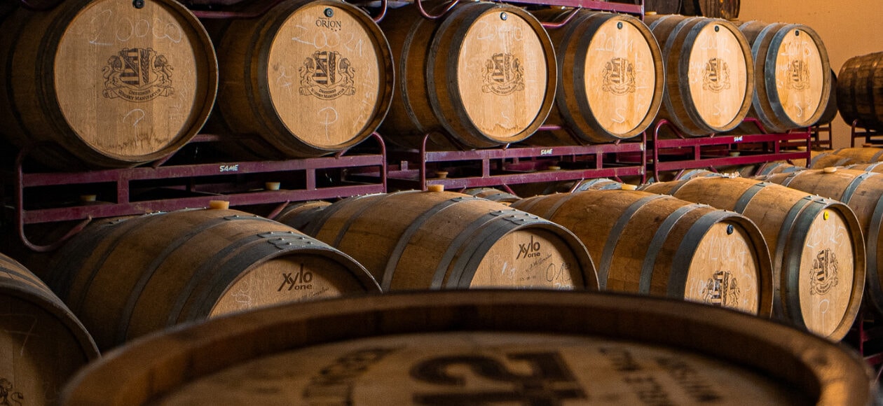 Zu sehen sind nebeneinander gelagerte Holzfässer der Dresdner Whisky Manufaktur.