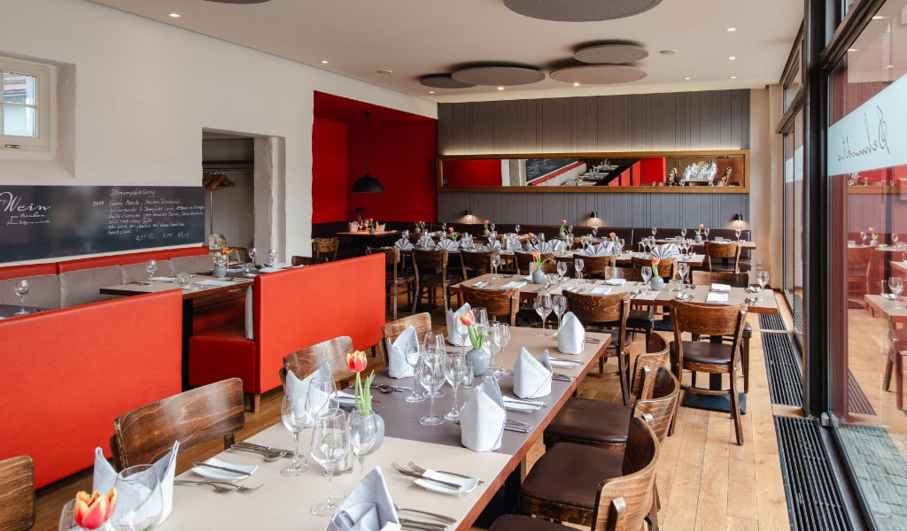 Elegant gedeckter Tisch in einem modernen Restaurant mit Servietten, Gläsern und Blumenarrangements