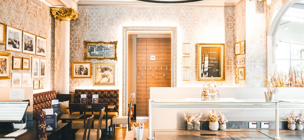 Blick in das Café Toscana mit Säulen und Tapeten.