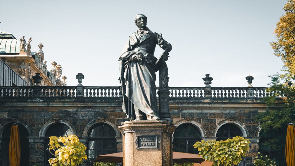Statue von Car Maria von Weber auf einem Marmorsockel am Theaterplatz in Dresden.