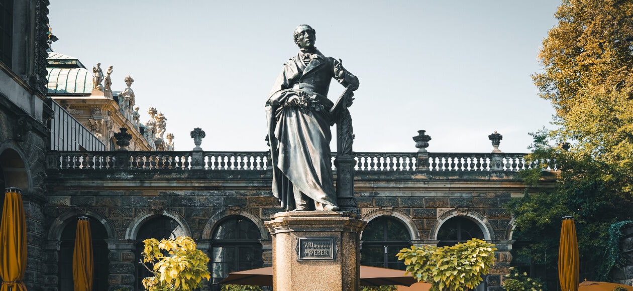 Statue von Car Maria von Weber auf einem Marmorsockel am Theaterplatz in Dresden.