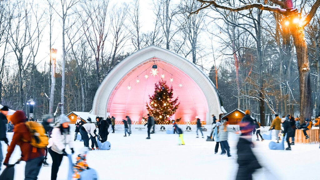 Eisläuferinnen und Eisläufer bewegen sich über die Eisfläche am Konzertplatz Weißer Hirsch in Dresden.
