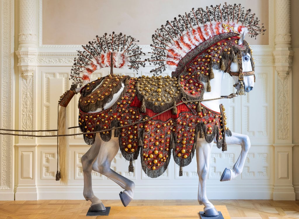 lebensgroße Pferdeplastik mit kunstvoll verziertem Zaumzeug voller Schellen 