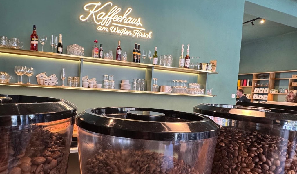 Geröstete Kaffeebohnen in transparenten Behältern vor der Theke des Kaffeehauses am Weißen Hirsch.