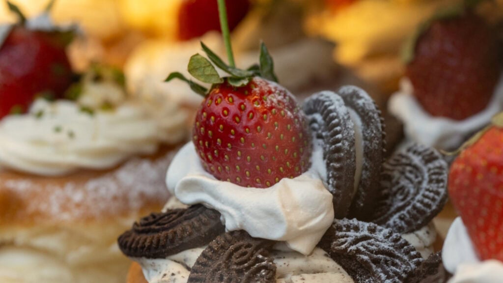 Gebäck, dekoriert mit Sahne, Oreo-Keks und einer Erdbeere