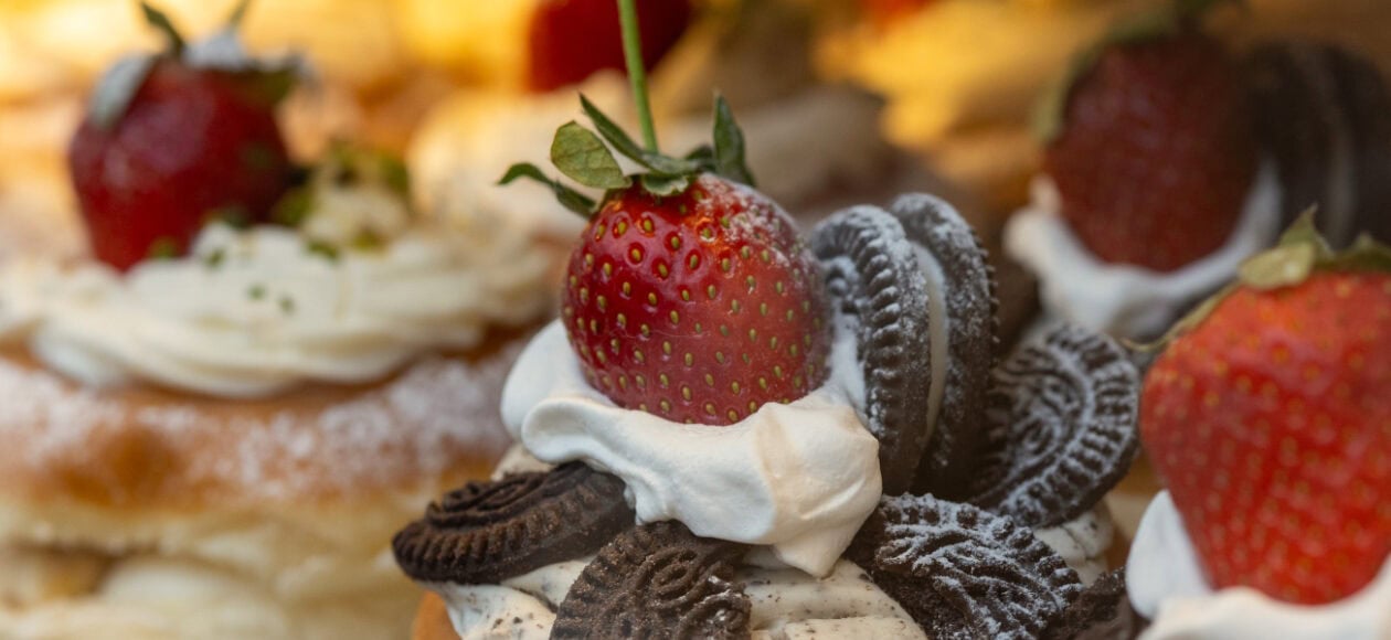 Gebäck, dekoriert mit Sahne, Oreo-Keks und einer Erdbeere