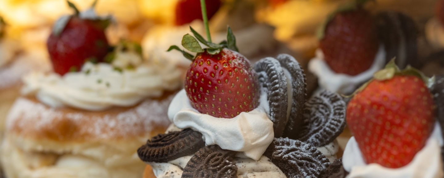 Gebäck, dekoriert mit Sahne, Oreo-Keks und einer Erdbeere