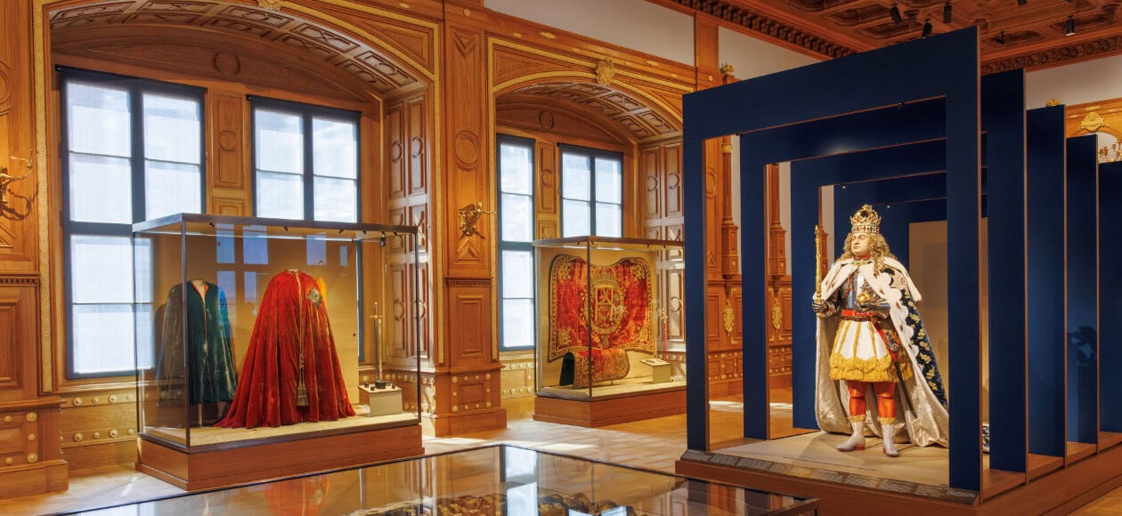 Königliche Gewänder und Krönungsmantel in Vitrinen, blauer Saal mit Rahmen im Residenzschloss Dresden Ausstellung