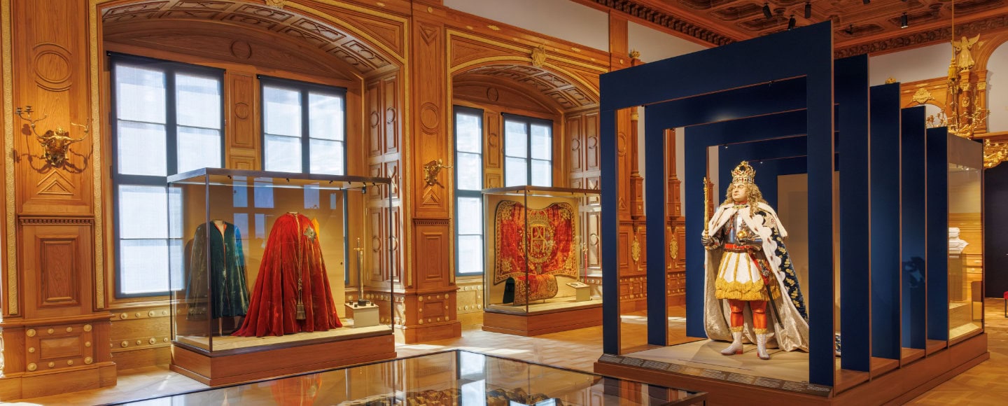 Königliche Gewänder und Krönungsmantel in Vitrinen, blauer Saal mit Rahmen im Residenzschloss Dresden Ausstellung