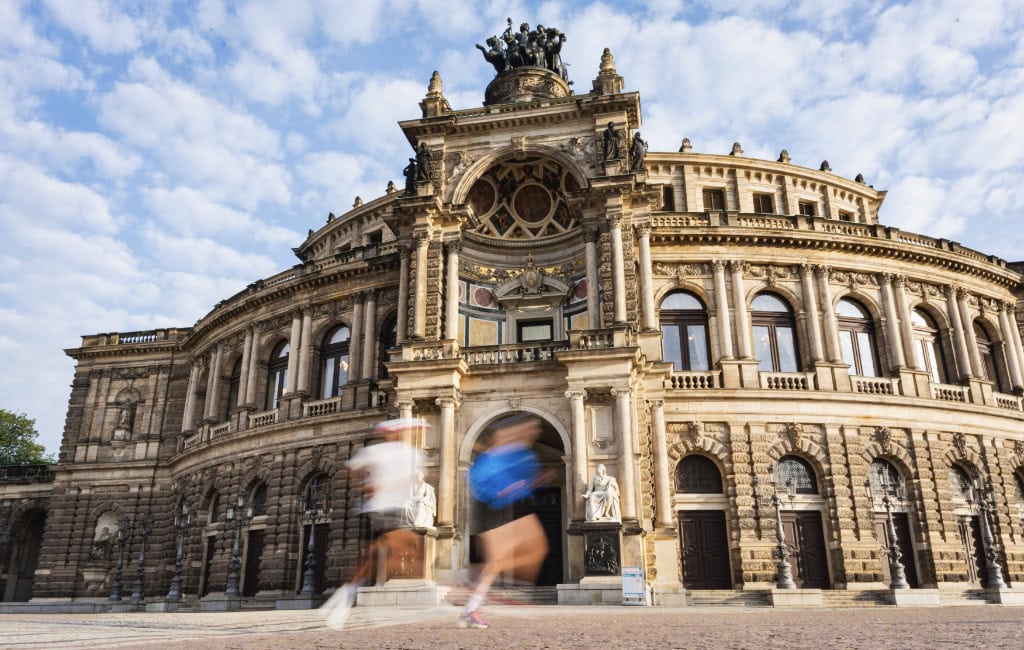 Zwei Jogger laufen an der Semperoper vorbei.