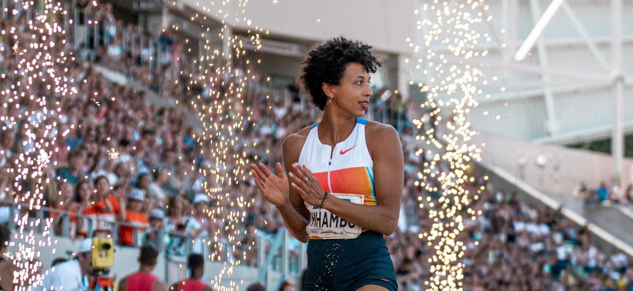 Leichtathletin klatscht zwischen Funkenfontänen vor voll besetzten Rängen beim Meeting Goldenes Oval Dresden im Stadion.