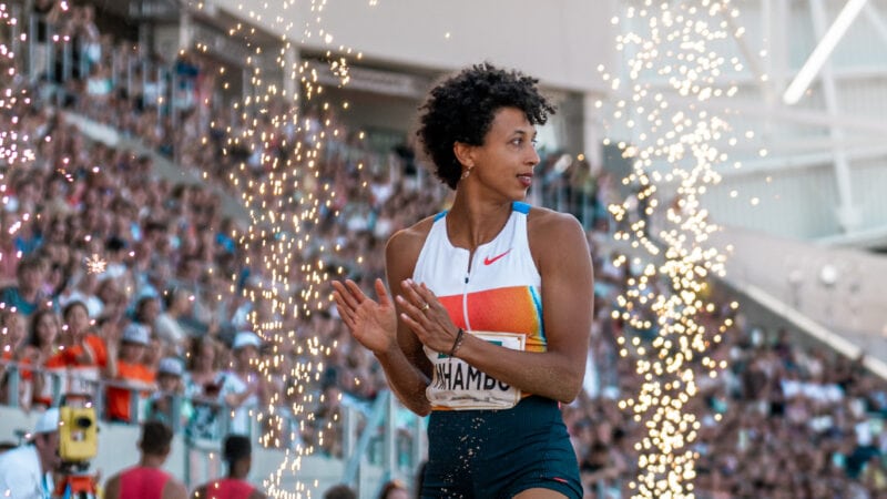 Leichtathletin klatscht zwischen Funkenfontänen vor voll besetzten Rängen beim Meeting Goldenes Oval Dresden im Stadion.
