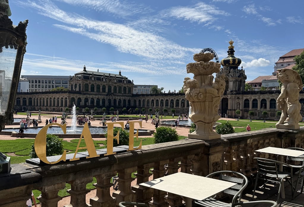 Blick von der Terrasse des Café The Pavilion auf den Innenhof des Dresdner Zwingers mit Brunnen und barocker Architektur.