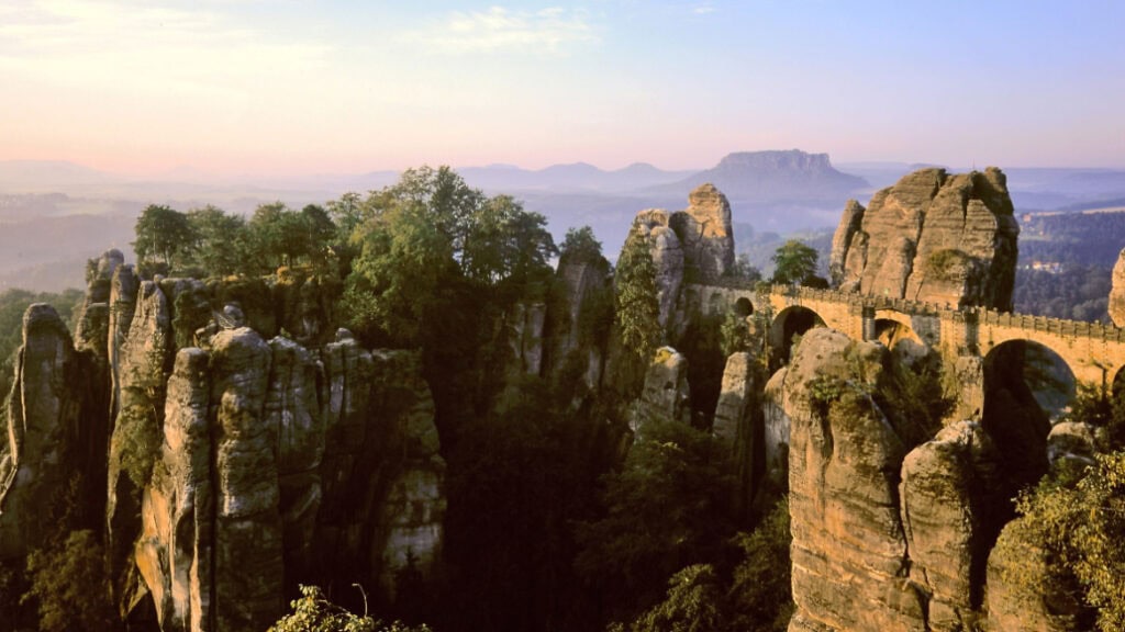 Spektaktuläre Felsen aus Sandstein, verbudnen durch die Basteibrücke im Abendlicht. Sandsteinfelsen gehauene Basteibrücke im Abendlicht.